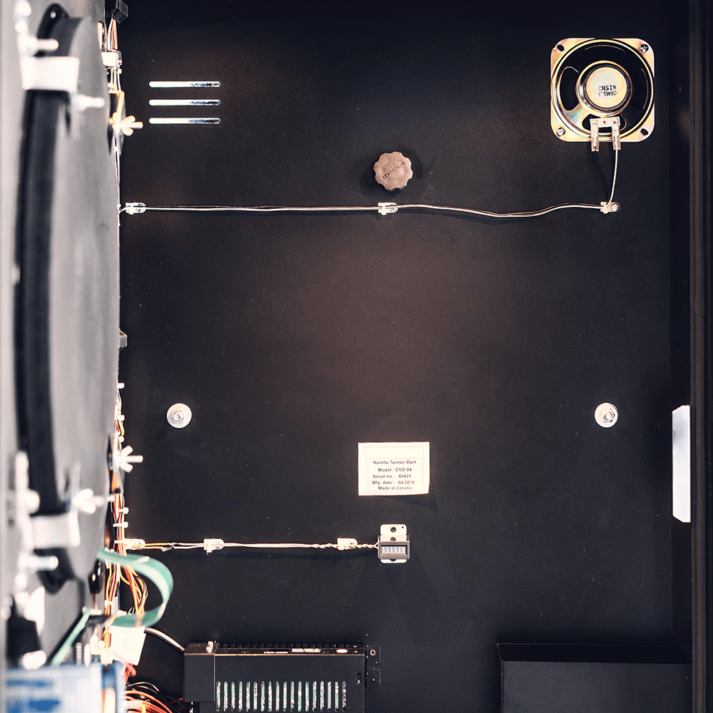 Karella_E-Master_Dartautomat_Detail_Innenansicht_B Das Bild zeigt das Innere des Karella E-MASTER Dartautomaten mit Münzeinwurf. Zu sehen sind verschiedene elektronische Bauteile und Kabel im Gehäuse.