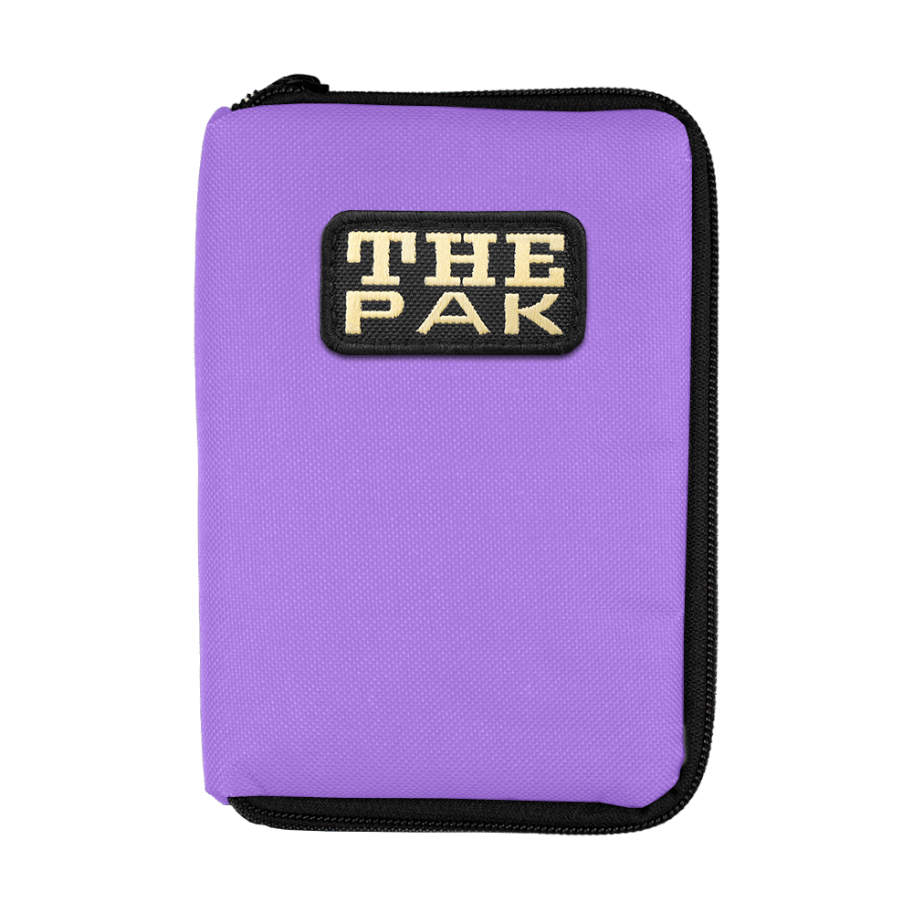 708TP_The_Pak_Dartcase_Violett_1 Das Bild zeigt ein lila Etui mit einem Reißverschluss. Auf der Vorderseite befindet sich ein Aufnäher mit der Aufschrift "THE PAK".