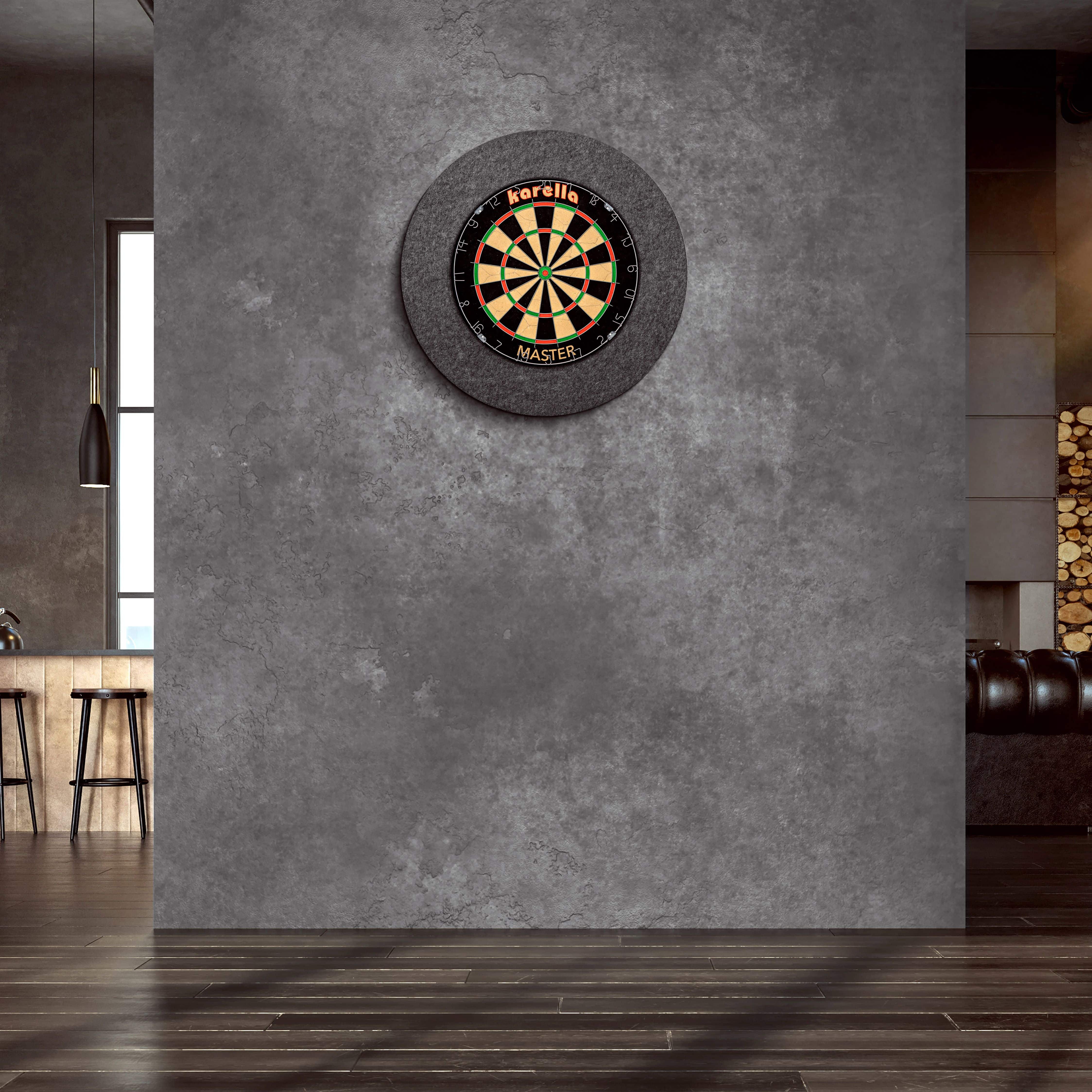 Marco de diana de acero Karella Ultimo An der Wand hängt ein "Karella Ultimo Steeldartboard Surround". Der Raum wirkt modern und stilvoll mit dunklen Farben und eleganter Einrichtung.