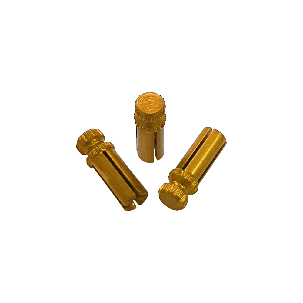 Das Bild zeigt drei goldfarbene Alu Flightschoner. Sie sind kleine, zylindrische Schutzkappen für Dart-Flights.