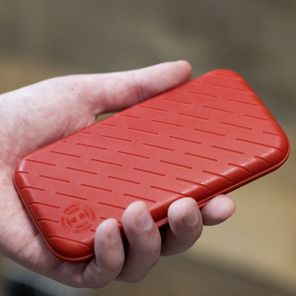 Estuche para dardos Harrows Slimcase Eine Person hält eine rote, strukturierte Darttasche in der Hand. Die Darttasche hat eine schlanke und kompakte Form.