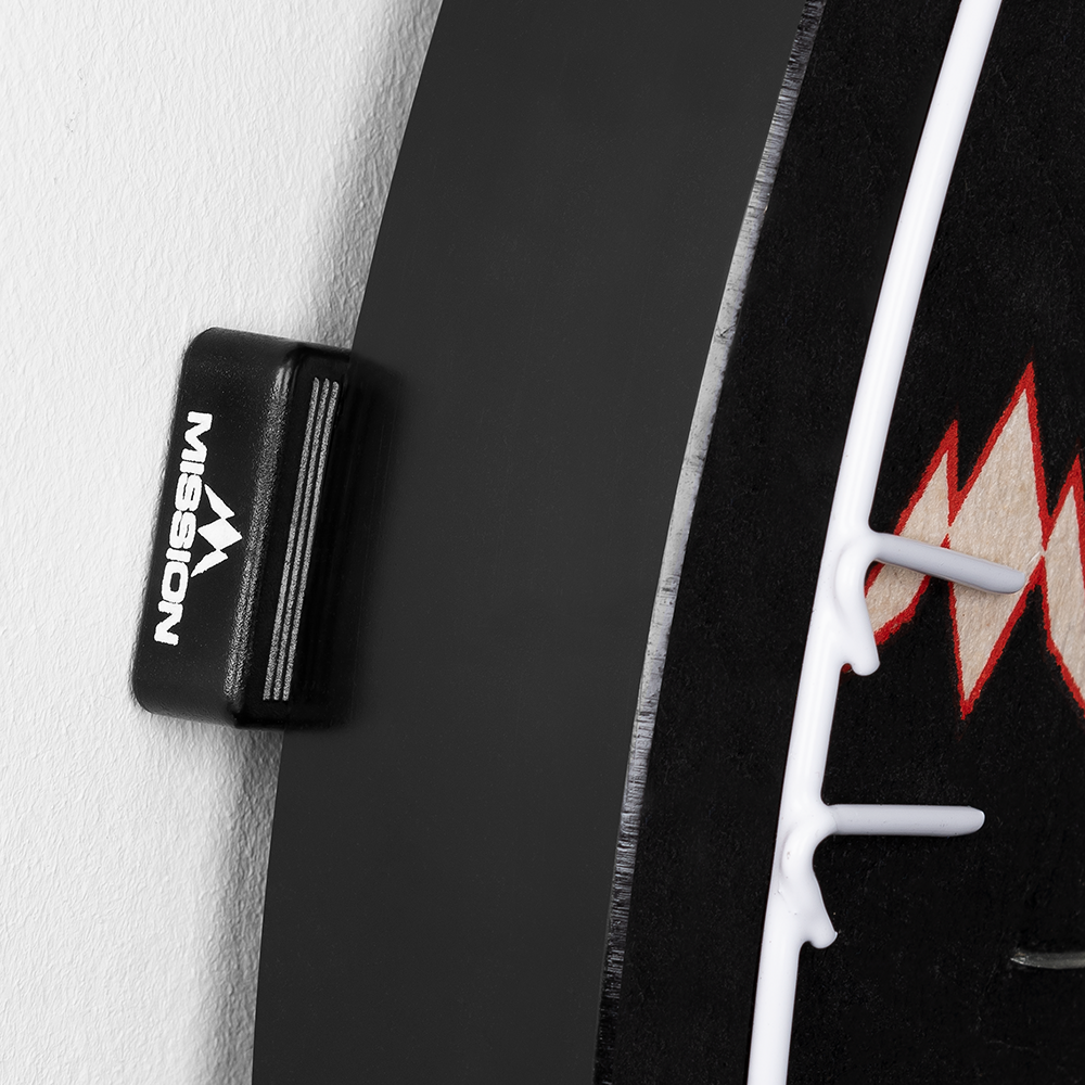 Das Bild zeigt einen Abstandshalter der Marke Mission, der an einem Dartboard befestigt ist. Der Abstandshalter sorgt dafür, dass das Dartboard gleichmäßig von der Wand absteht.