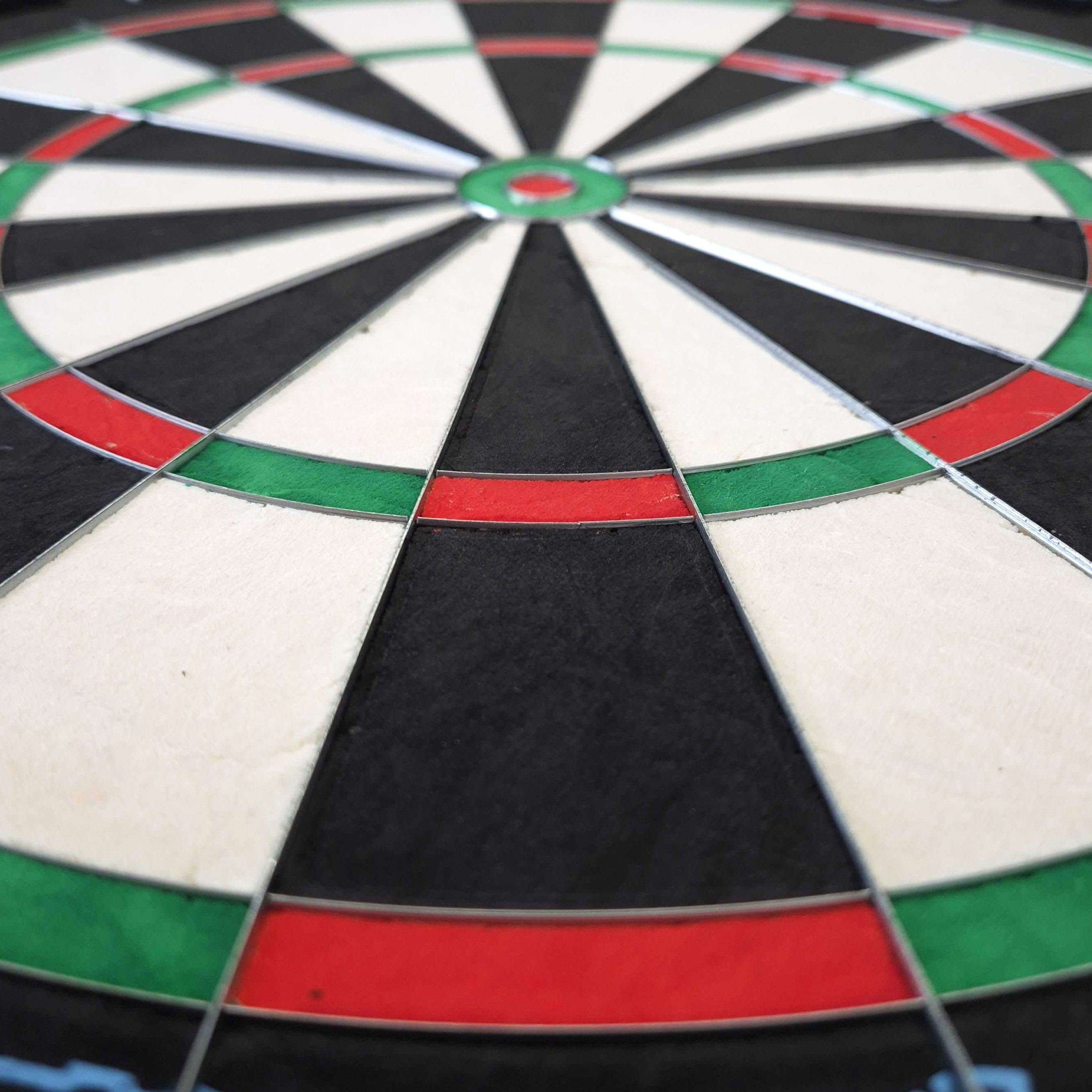 Diana de dardos de acero Mission Samurai Infinity Das Bild zeigt eine Nahaufnahme eines Steeldartboards mit klar erkennbaren Farbfeldern in Rot, Grün, Schwarz und Weiß. Es handelt sich um das Produkt "Mission Samurai Infinity Steeldartboard".
