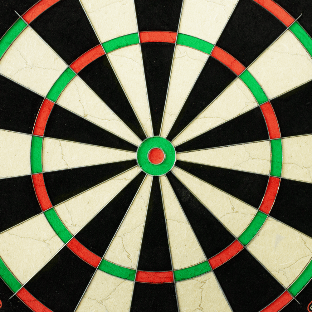 3033_Winmau_Blade_6_Steeldartboard_3 Das Bild zeigt eine Nahaufnahme des Winmau Blade 6 Steeldartboards. Die farbigen Segmente in Schwarz, Weiß, Rot und Grün sind deutlich zu erkennen.