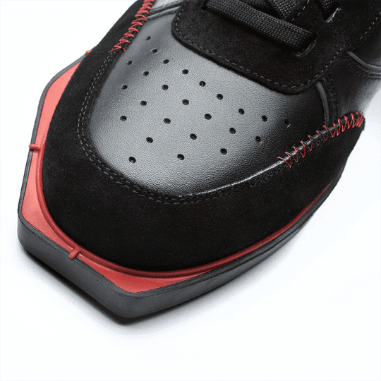 20101001-00_Triple20_Dartschuhe_Leder_Schwarz_Rot_4 Der Schuh besteht aus schwarzem Leder mit roten Akzenten und auffälligen roten Nähten. Die Schuhspitze ist kantig geformt und hat kleine Belüftungslöcher.