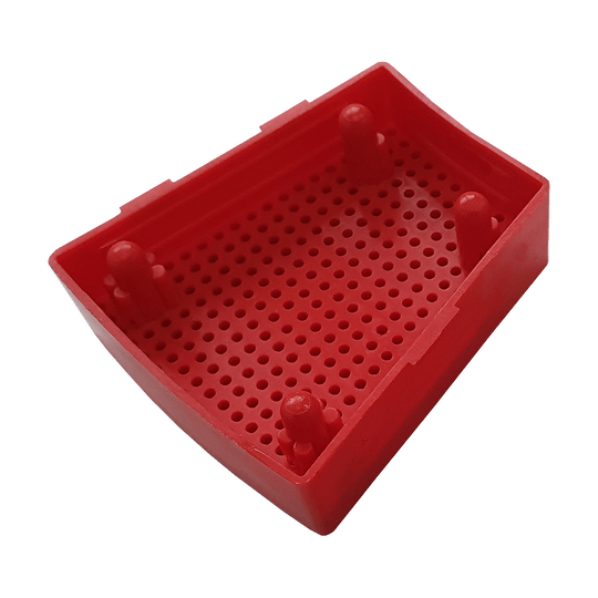 GRN0151_Granboard_132_Ersatzfelder_Single_Aussen_Rot_3 Das Bild zeigt ein rotes Ersatzfeld für das Granboard 132. Das Kunststoffteil hat eine rechteckige Form mit vielen kleinen Löchern und vier Erhebungen.