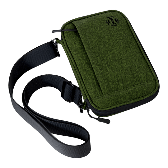 Auf dem Bild ist eine grüne Tragetasche mit einem schwarzen Schultergurt zu sehen. Die Tasche hat eine Klappe und wirkt robust und modern.