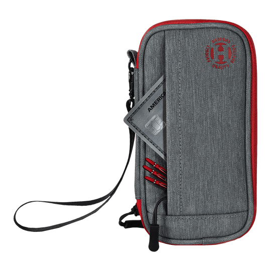 Cartera inteligente Harrows Dartcase Das Bild zeigt ein graues und rotes Dart-Etui mit einem Reißverschluss und einer Handschlaufe. In der Vordertasche stecken eine Kreditkarte und einige Dartspitzen.