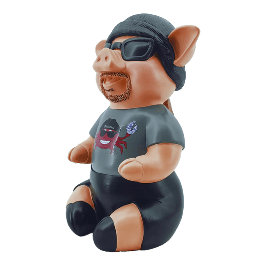 Markus Krebs Frase Cerdo Das Bild zeigt eine Schweinfigur namens "Markus Krebs Phrasenschwein". Sie trägt eine Sonnenbrille, eine Mütze und ein T-Shirt mit Aufdruck.