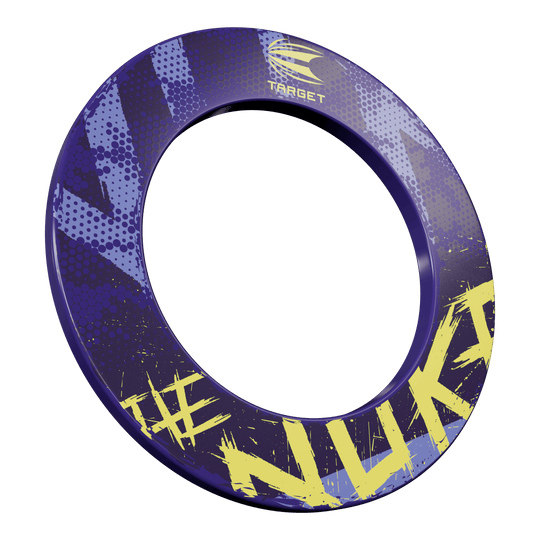 Target Luke Littler El tablero de dardos Nuke Surround Das Bild zeigt eine Dartboard-Umrandung mit dem Namen „Target Luke Littler The Nuke Dartboard Surround“. Die Umrandung ist hauptsächlich lila mit gelben Schriftzügen und Mustern gestaltet.