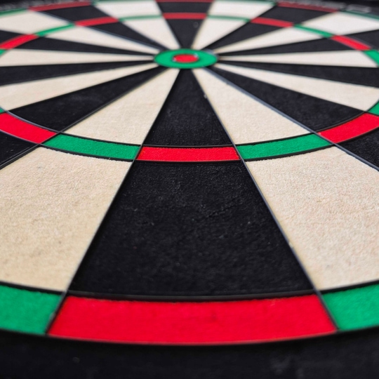 Diana de dardos de acero Unicorn Eclipse Ultra 2.0 Das Bild zeigt ein Unicorn Eclipse Ultra 2.0 Steeldartboard aus der Nähe. Die farbigen Felder in Rot, Grün, Schwarz und Weiß sind deutlich zu erkennen.