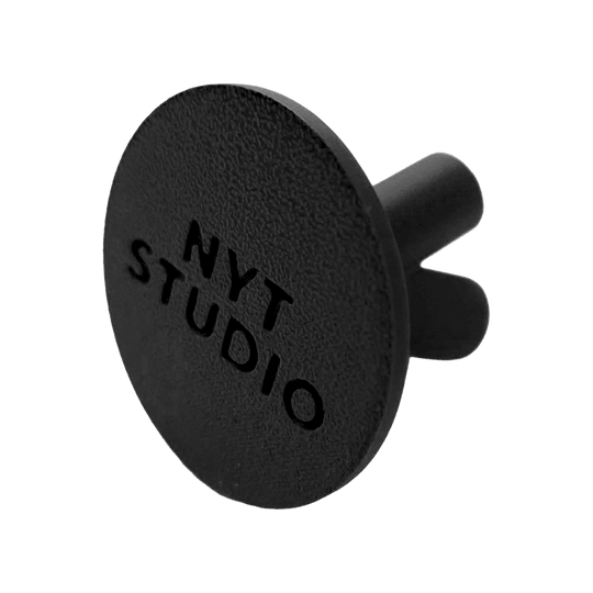 Soporte para dardos compacto NYT Studio Das Bild zeigt einen schwarzen, kompakten Dart-Halter. Es handelt sich um den NYTStudio Compact Darts Halter.