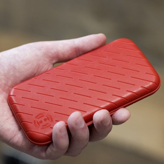 Estuche para dardos Harrows Slimcase Eine Person hält eine rote, strukturierte Darttasche in der Hand. Die Darttasche hat eine schlanke und kompakte Form.