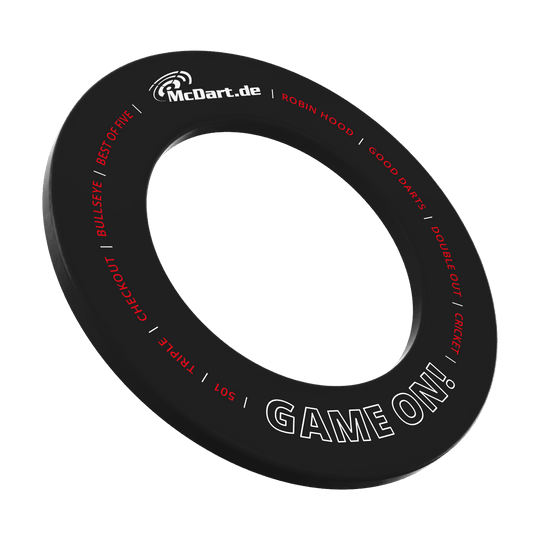 Juego de dardos McDart en la diana Das Bild zeigt einen schwarzen Dartboard-Surround-Ring mit der Aufschrift "McDart.de" und "GAME ON!". Um den Ring sind weitere Begriffe rund um das Dartspiel in Rot und Weiß geschrieben.