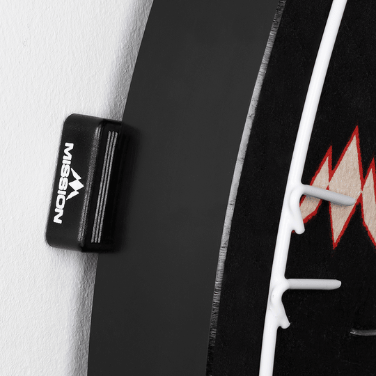 Separadores de cuñas para diana Mission (juego de 8) Das Bild zeigt einen Abstandshalter der Marke Mission, der an einem Dartboard befestigt ist. Der Abstandshalter sorgt dafür, dass das Dartboard gleichmäßig von der Wand absteht.