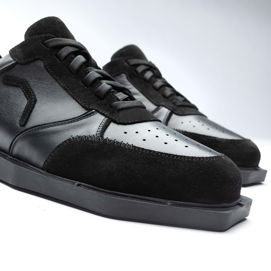 20100006-00_Triple20_Dartschuhe_Leder_Schwarz_4 Auf dem Bild sind schwarze Lederschuhe namens "Triple20 Dartschuhe Leder - Schwarz" zu sehen. Die Schuhe haben eine sportliche Form und bestehen aus einer Kombination von Glattleder und Wildleder.