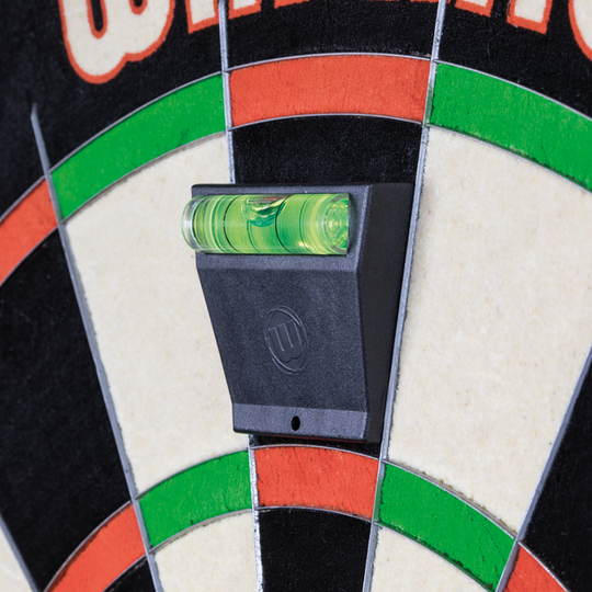 Winmau_Spirit_Master_Wasserwaage_3 Das Bild zeigt eine Winmau Spirit Master Wasserwaage, die an eine Dartscheibe angebracht ist. Die Wasserwaage hilft dabei, die Dartscheibe exakt waagrecht auszurichten.
