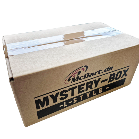 Caja misteriosa de McDart - Estilo L Auf dem Bild ist ein brauner Karton mit der Aufschrift „McDart.de MYSTERY-BOX -L-STYLE-“ zu sehen. Die Box ist mit Klebeband verschlossen.
