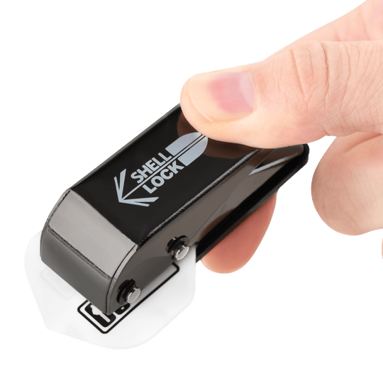 Punzón de bloqueo de carcasa One80 estilo L Das Bild zeigt das Produkt "L-Style One80 Shell Lock Punch Flightlocher", das in einer Hand gehalten wird. Mit diesem Werkzeug wird ein Loch in ein Dartflight gestochen.