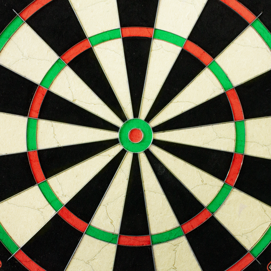 3033_Winmau_Blade_6_Steeldartboard_3 Das Bild zeigt eine Nahaufnahme des Winmau Blade 6 Steeldartboards. Die farbigen Segmente in Schwarz, Weiß, Rot und Grün sind deutlich zu erkennen.
