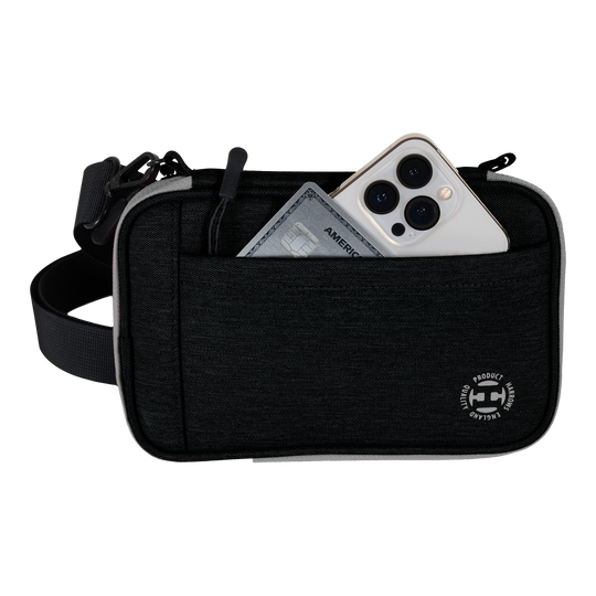 Cartera para dardos Harrows Smart Case XL Auf dem Bild ist eine schwarze Harrows Smart Case XL Darttasche zu sehen. In der vorderen Tasche stecken ein Smartphone und eine Kreditkarte.
