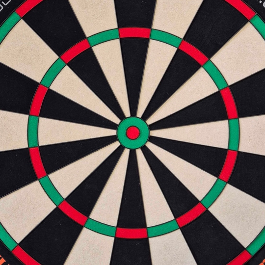 Diana de dardos de acero Unicorn Eclipse Ultra 2.0 Das Bild zeigt eine Nahaufnahme einer Dartscheibe mit klaren Farbfeldern in Schwarz, Weiß, Rot und Grün. Es handelt sich um das Produkt "Unicorn Eclipse Ultra 2.0 Steeldartboard".