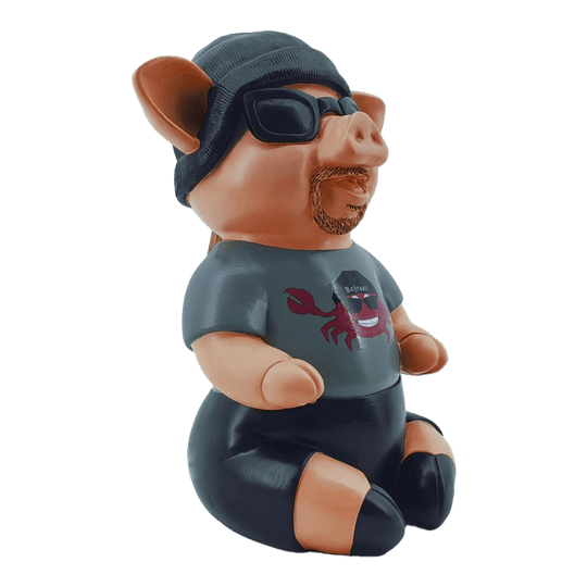 Markus Krebs Frase Cerdo Das Bild zeigt das Produkt "Markus Krebs Phrasenschwein". Die lustige Figur ist als Schwein gestaltet und trägt Sonnenbrille, Mütze und T-Shirt.