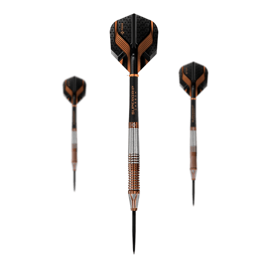 Dardos de acero Harrows Toro Auf dem Bild sind drei Steeldarts zu sehen, wobei einer mittig im Vordergrund steht und die anderen beiden im Hintergrund sind. Die Darts haben schwarze und orangefarbene Flights sowie silberne und bronzefarbene Griffe.