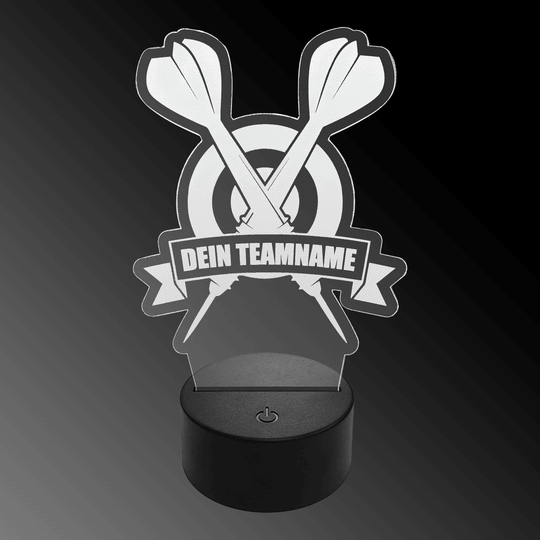 Lámpara de dardo LED de plexiglás con texto personalizado Das Bild zeigt eine LED-Lampe aus Plexiglas in Form von zwei gekreuzten Dartpfeilen vor einer Zielscheibe. Auf einem Banner steht der Text "DEIN TEAMNAME".