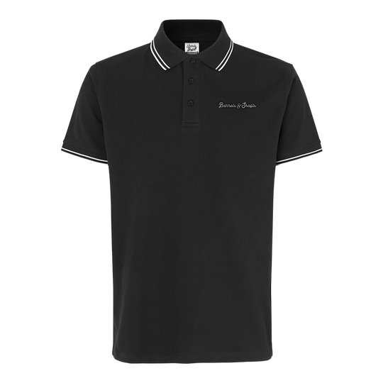Polo Barriles y Ejes - Negro Das Bild zeigt ein schwarzes Poloshirt mit weißen Akzenten an Kragen und Ärmeln. Auf der Brust ist der Schriftzug "Barrels & Shafts" eingestickt.